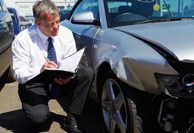 black car with insurance paperwork and keys on a desk